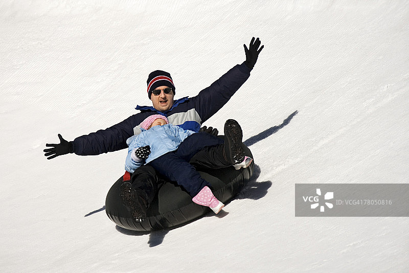 男人和女孩在内胎上滑雪图片素材
