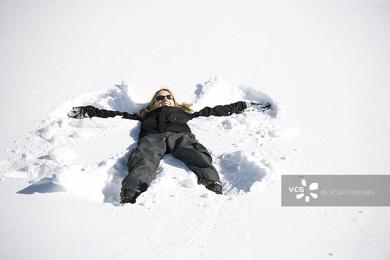 在雪地里做雪天使的女人图片素材