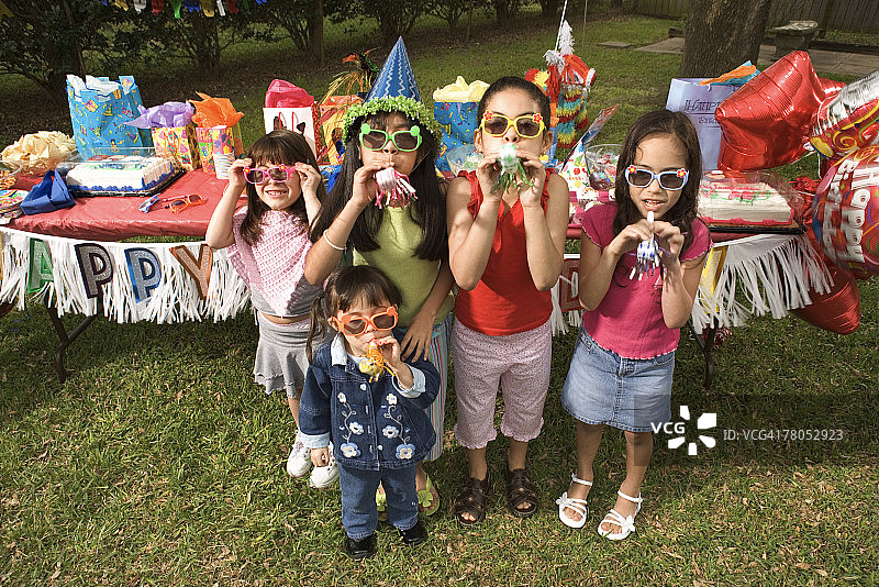 女孩们在户外生日派对上使用响板图片素材