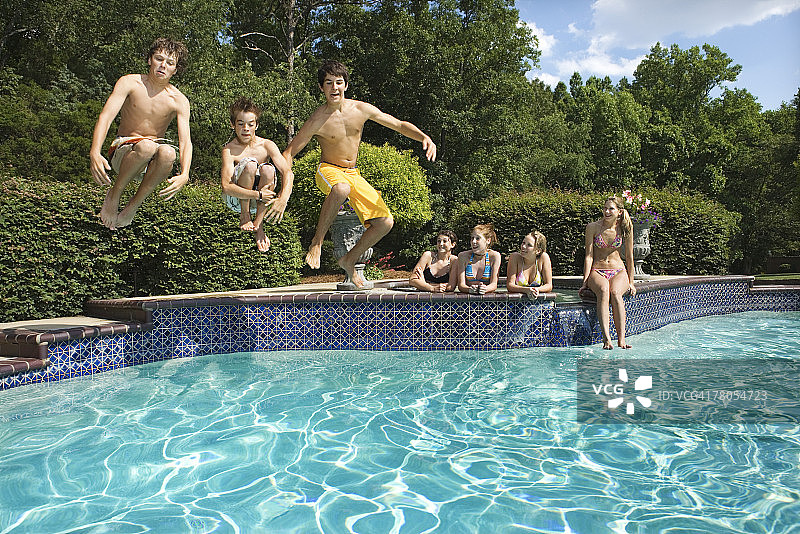 青少年在泳池里玩炮弹跳水图片素材