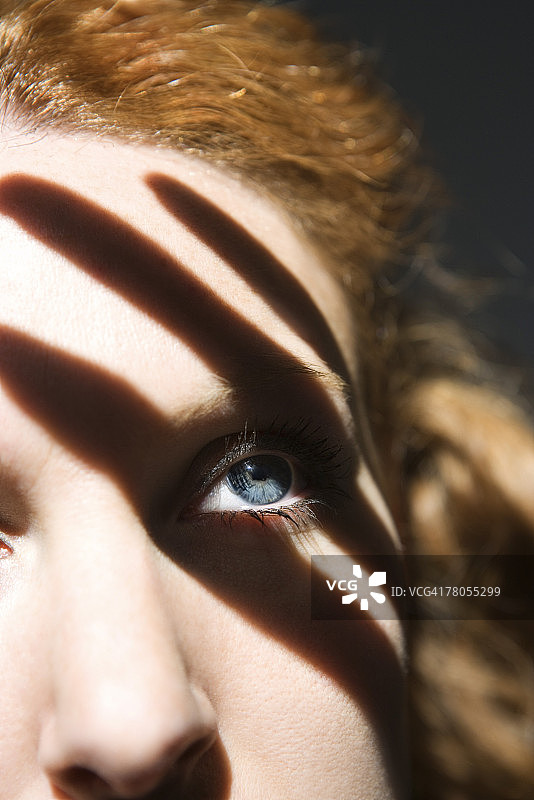 透过手指阴影看东西的女人图片素材