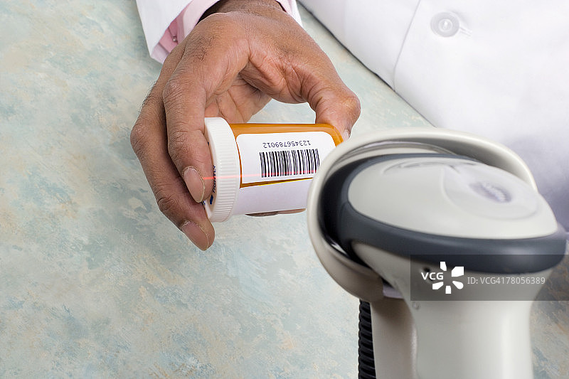 药剂师扫描药瓶上的条形码图片素材