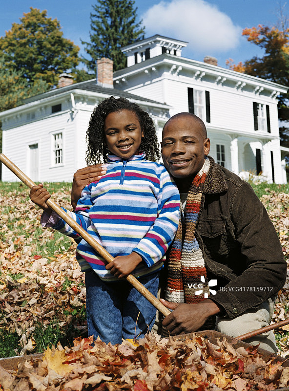 男人和女孩耙树叶图片素材