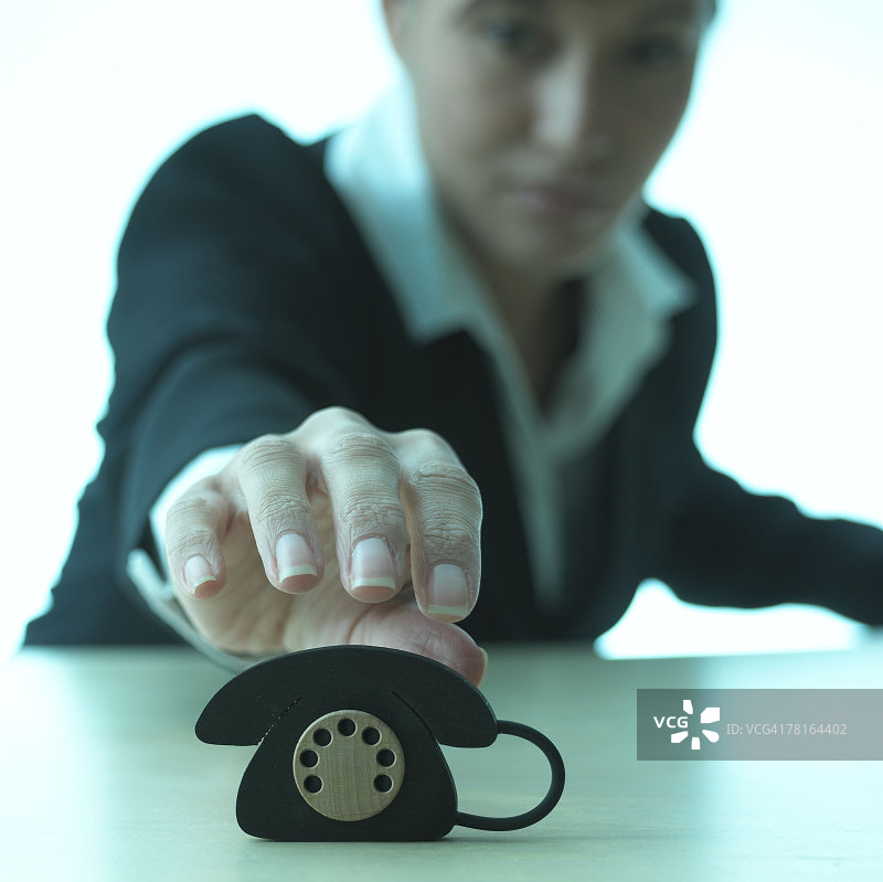 拿着迷你电话的女商人图片素材