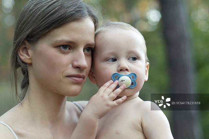 严肃的母亲抱着小婴儿图片素材