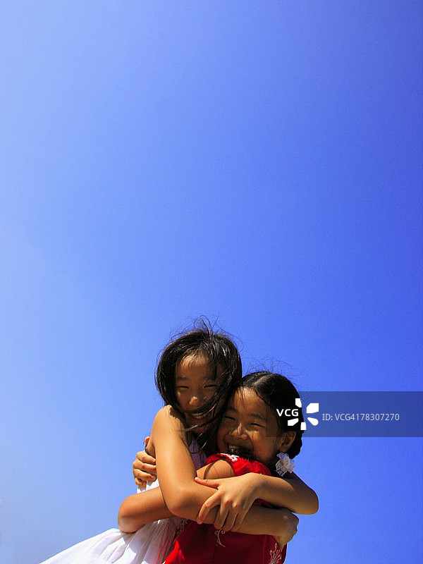 两个女孩互相拥抱微笑的侧面轮廓图片素材