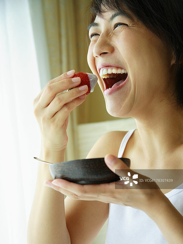 年轻女子吃草莓的特写图片素材
