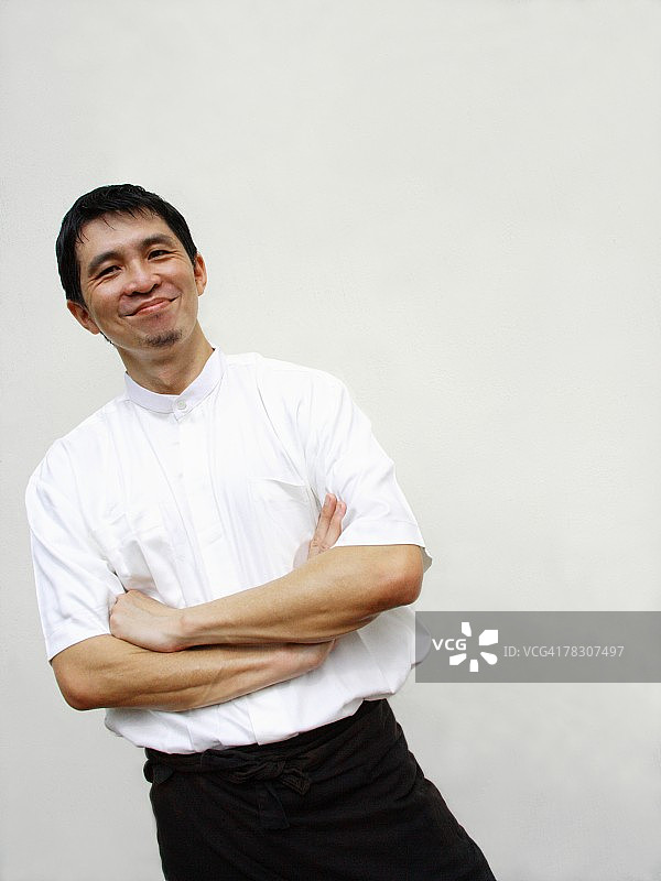 交叉双臂咧嘴笑的中年男人肖像图片素材