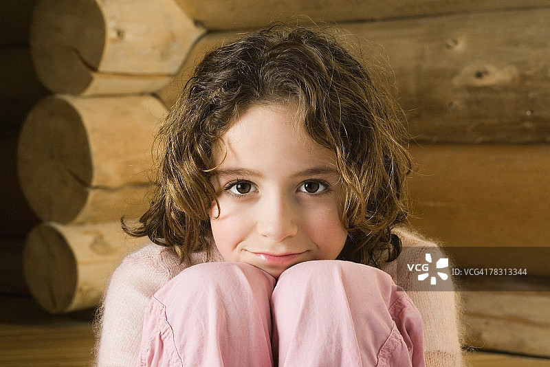 女孩双手抱膝，对着镜头微笑图片素材