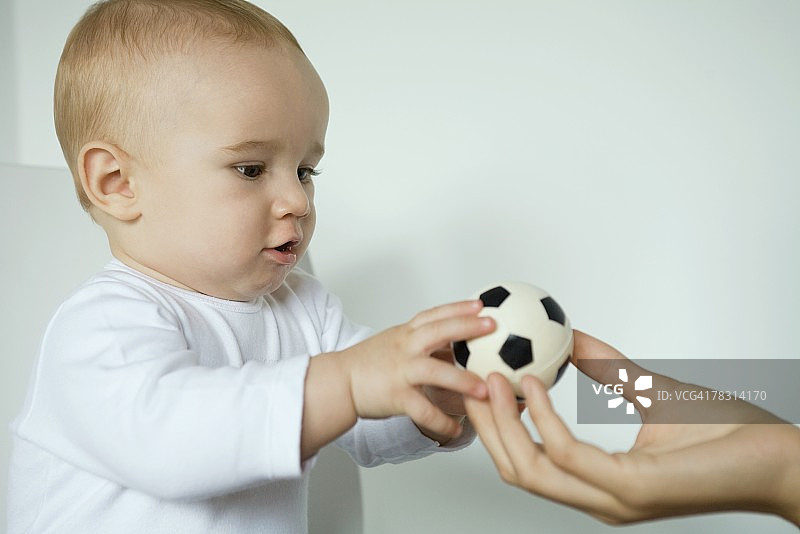 宝宝从妈妈手中拿球，特写图片素材