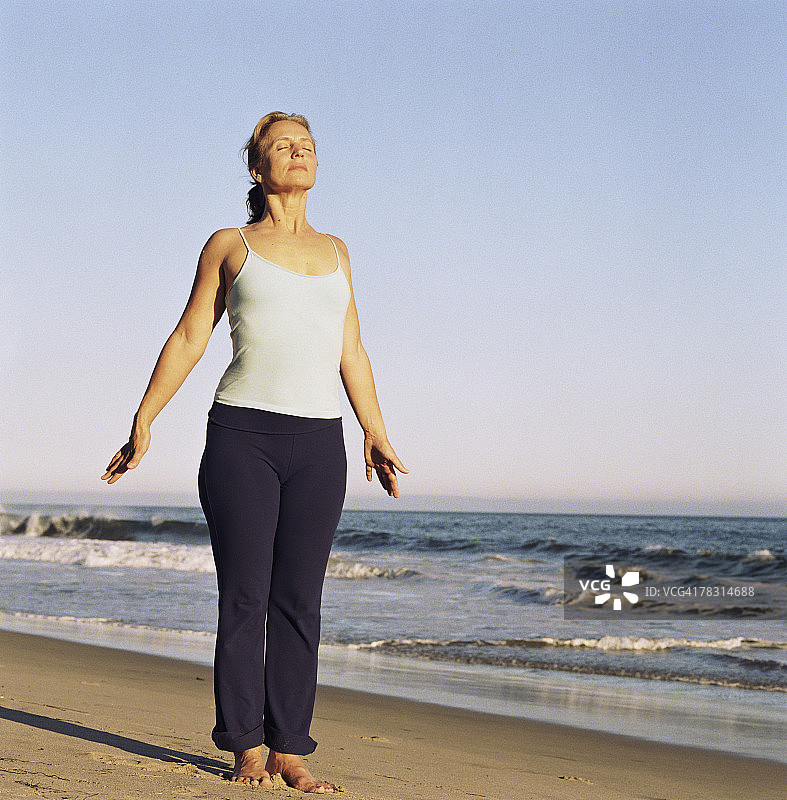 在海滩上做瑜伽的女人图片素材