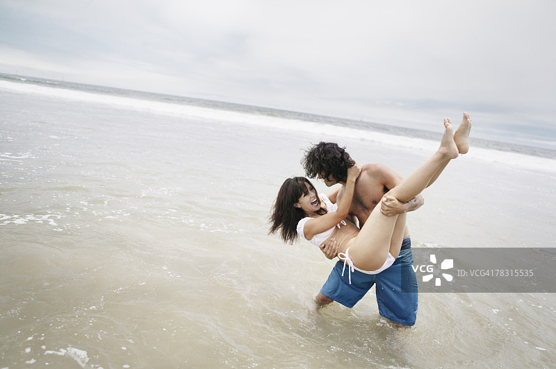 男人抱着女人在沙滩上图片素材