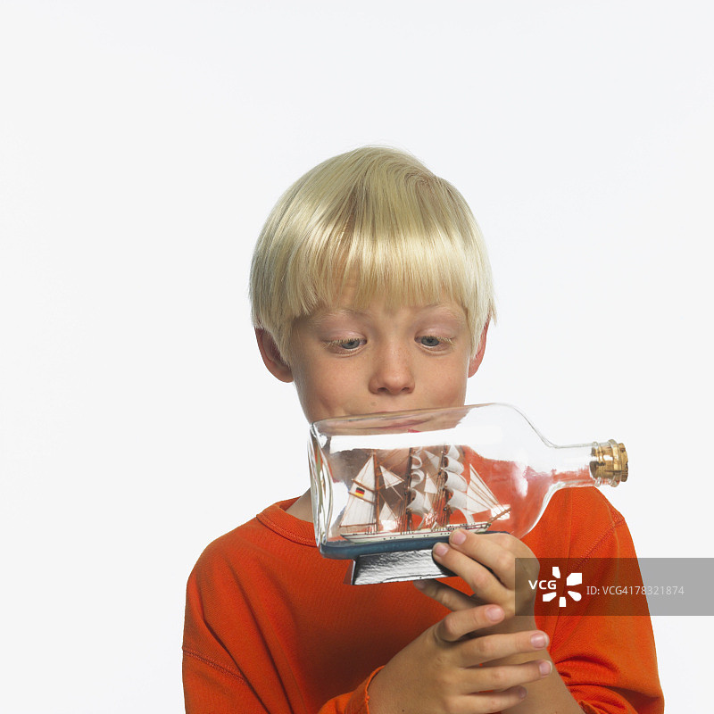 男孩正在看瓶中船图片素材