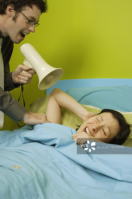 男人用扩音器叫醒女人图片素材