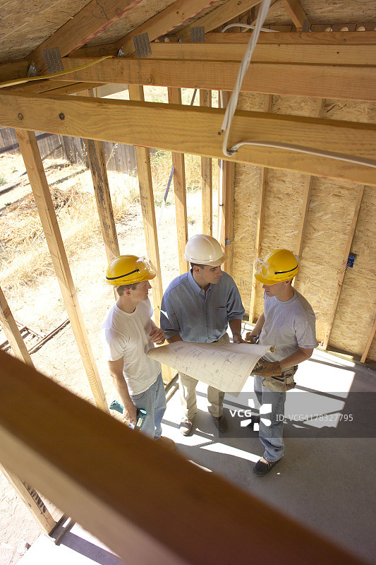 建筑工人与工人们一起审查计划图片素材