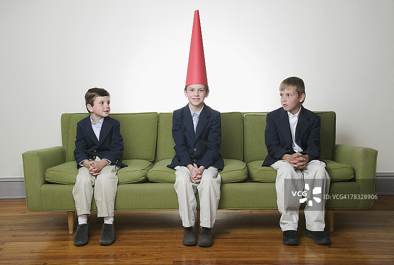 男孩们看着戴着呆子帽的男孩图片素材