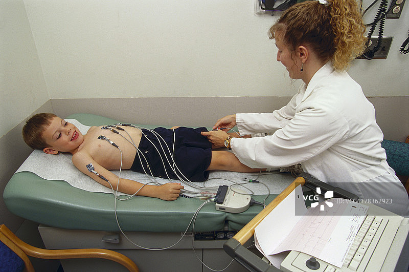 医生用心脏监护仪检查男孩图片素材