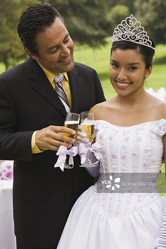 父亲和十几岁的女儿在成人礼上敬酒图片素材