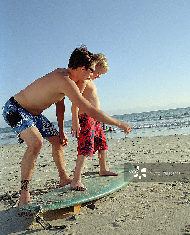 父子在海滩上冲浪图片素材