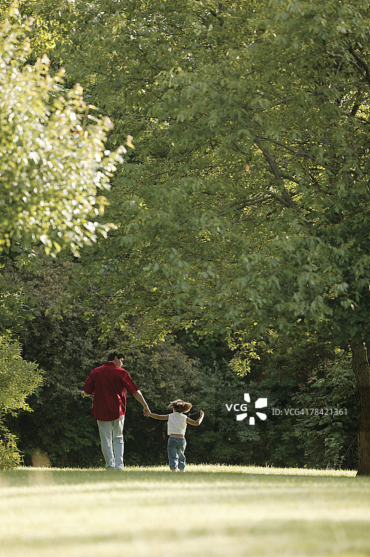 父女穿过公园图片素材