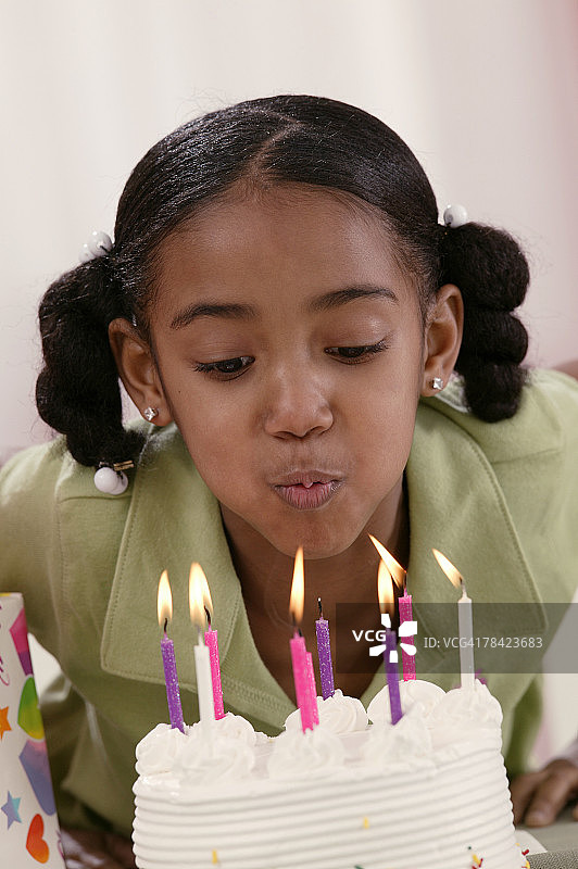 女孩吹灭生日蜡烛图片素材