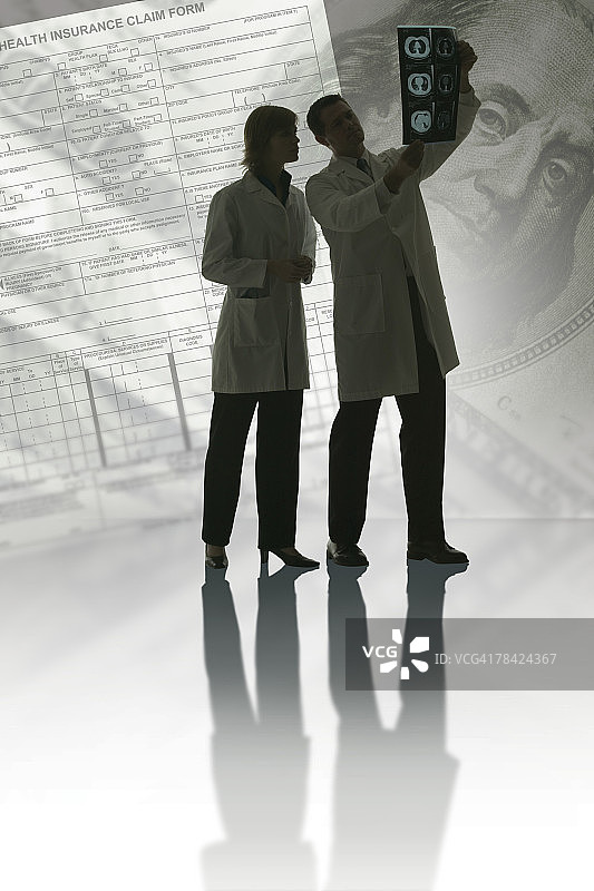 医生正在查看X光片、钞票和文件图片素材