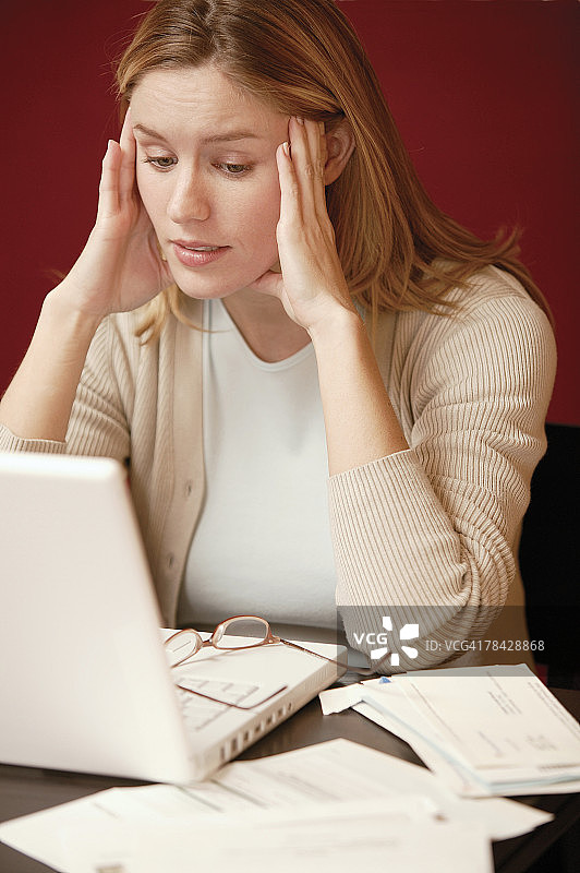 压力大的女人用笔记本电脑和文件图片素材