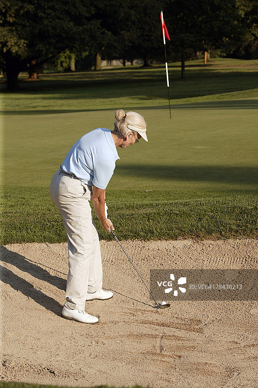 从沙坑中击球的女人图片素材