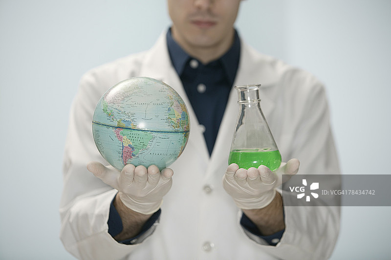 科学家手持地球仪和烧杯图片素材