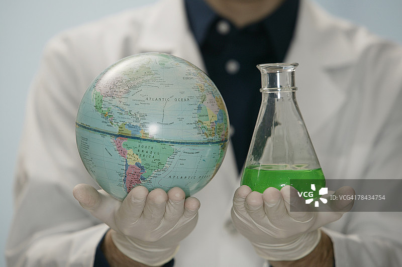 科学家手持地球仪和烧杯图片素材