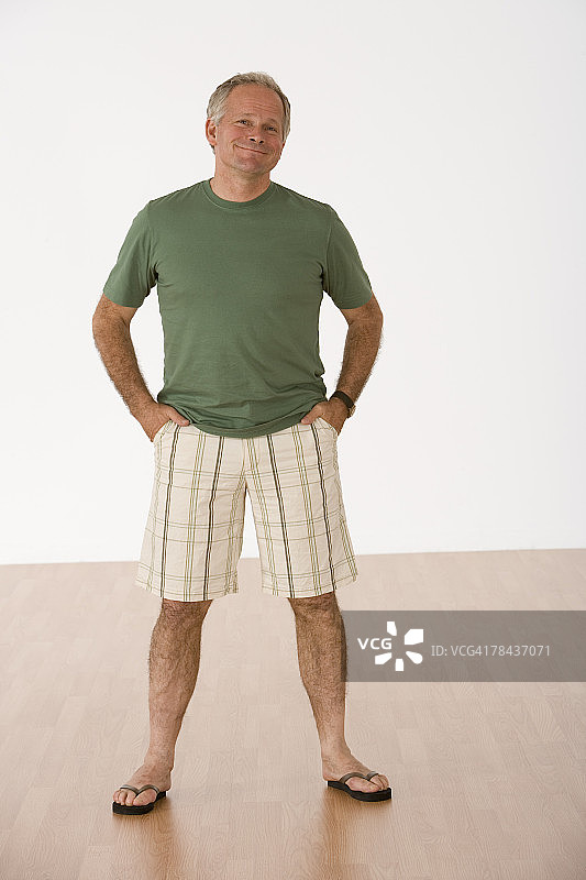 笑容满面的男人双手插在口袋里站立图片素材