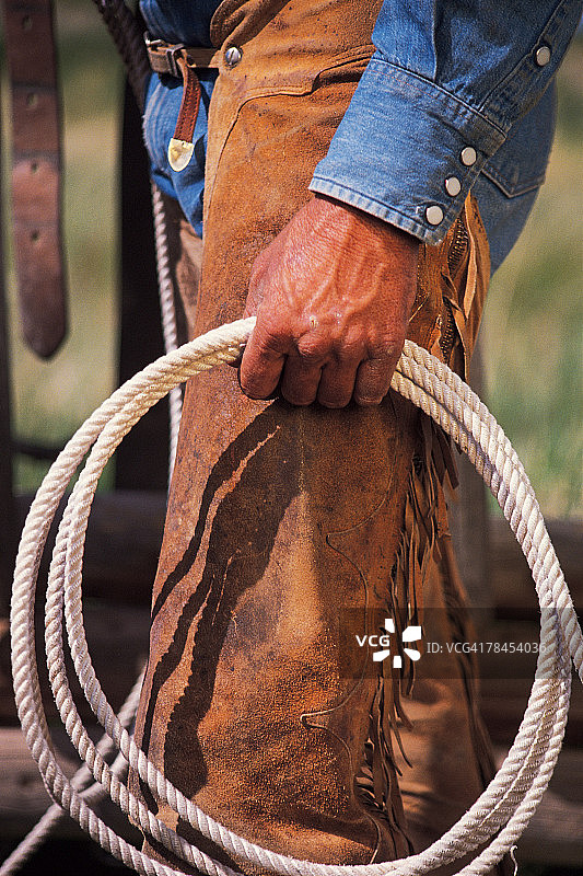 戴着护腿套裤的牛仔拿着套索图片素材