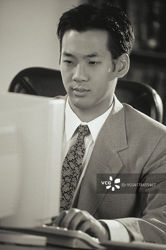 在办公桌前用电脑工作的商人图片素材