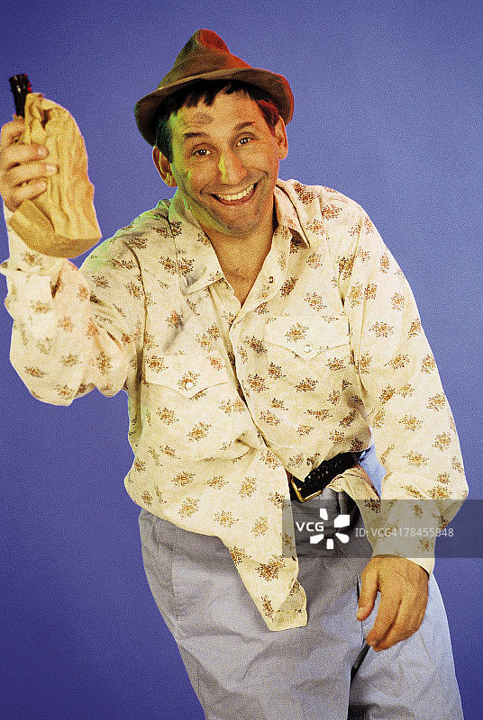 醉酒的流浪汉拿着装酒的纸袋图片素材