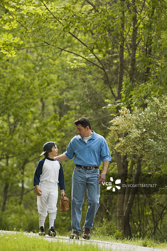 男人和小联盟球员一起走路图片素材