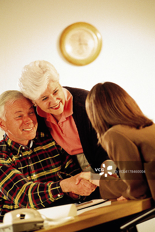老年夫妇与女商人握手图片素材