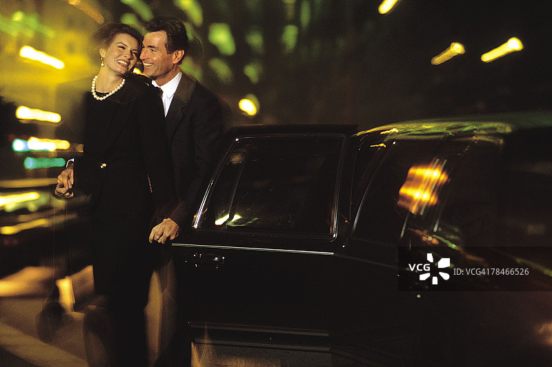 情侣夜晚站在豪华轿车旁图片素材