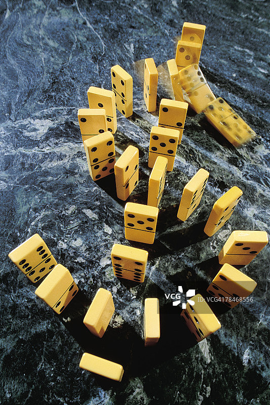 排列成美元符号形状的掉落多米诺骨牌图片素材