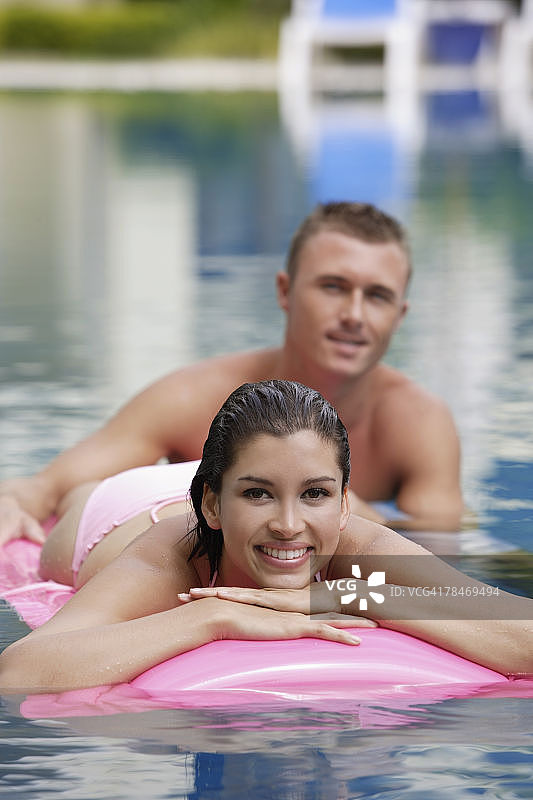 躺在泳池气垫上的男人和女人图片素材