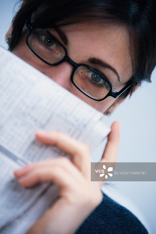 女人从报纸后面偷看图片素材
