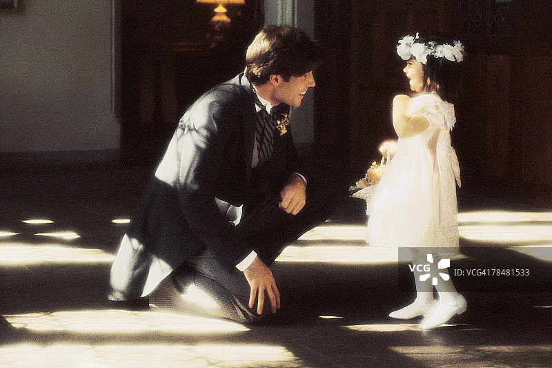 穿燕尾服的男人与花童在婚礼招待会上图片素材