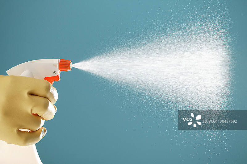 戴橡胶手套的手喷洒清洁剂图片素材