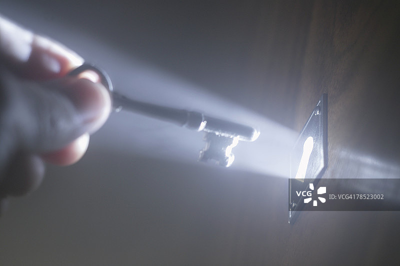 钥匙孔插钥匙的人（带光线）图片素材