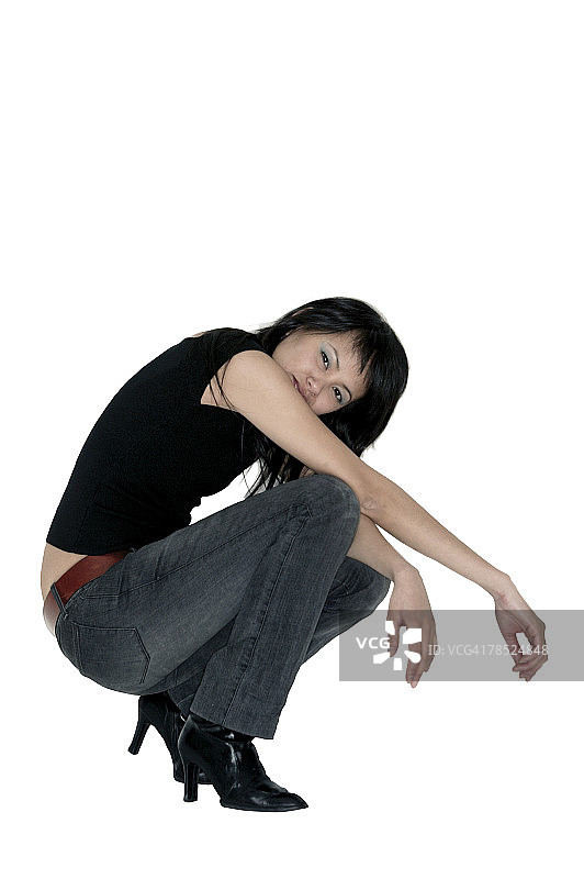 穿着蓝色牛仔裤摆姿势的女人侧视图图片素材