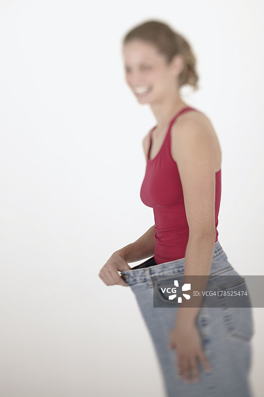穿着旧大号裤子的女人图片素材