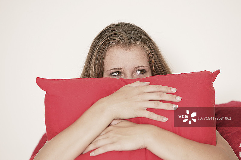 少女躲在枕头后面图片素材