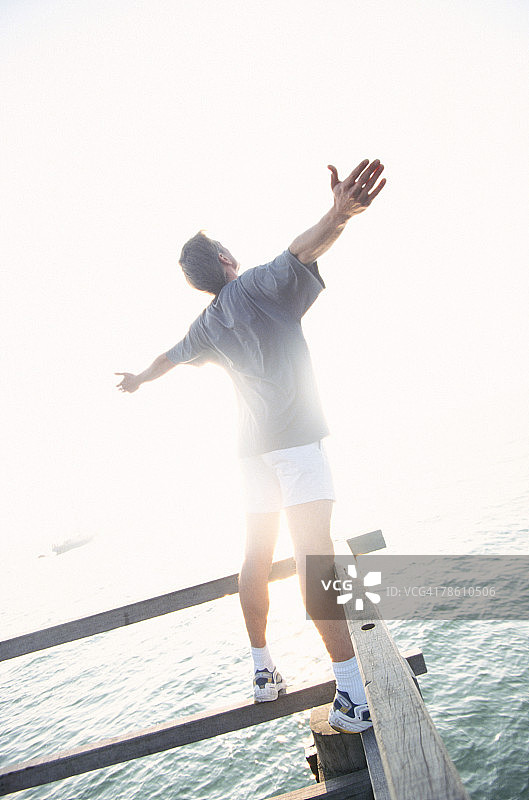 在海边张开双臂的男人图片素材