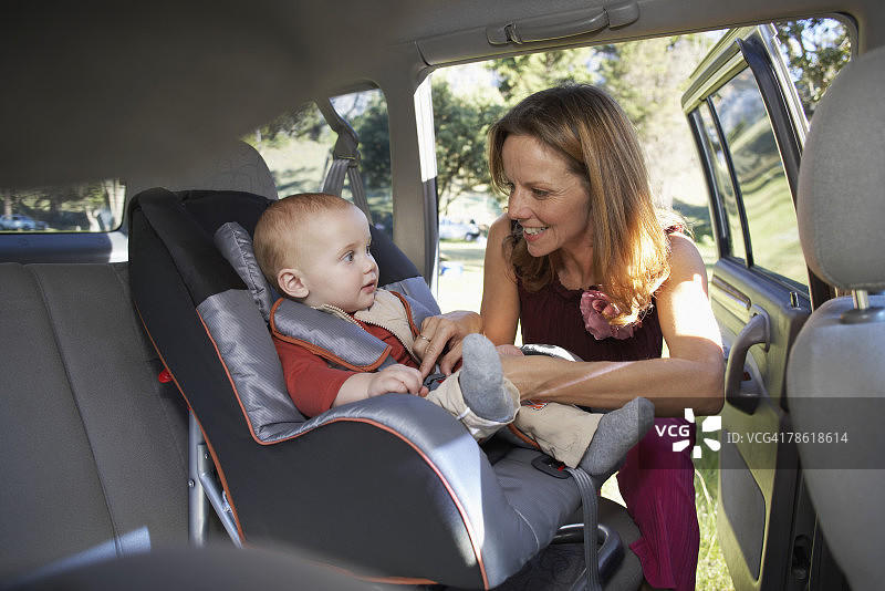 母亲为宝宝固定汽车安全座椅图片素材