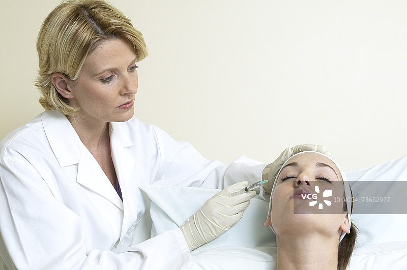 医生为妇女注射肉毒杆菌毒素图片素材