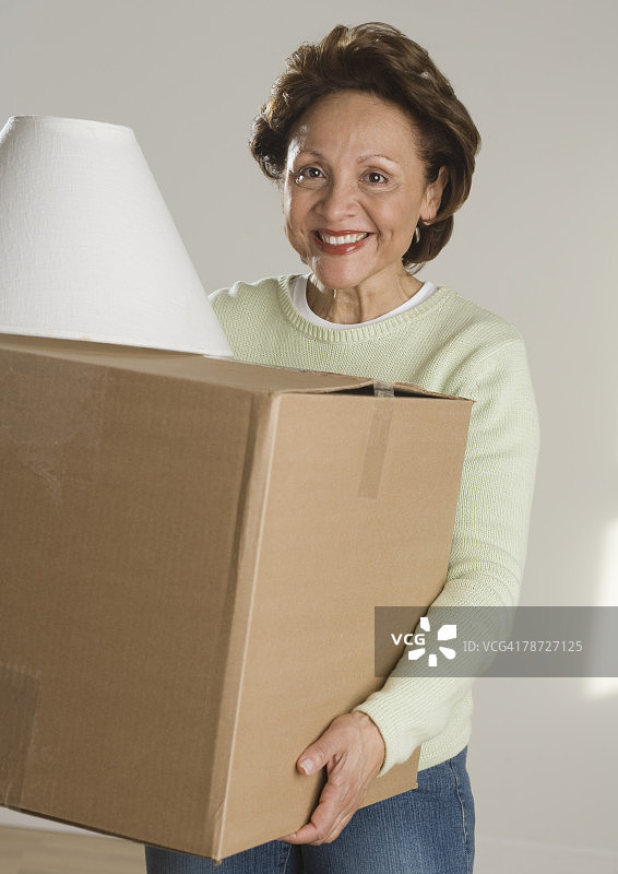 女人搬运箱子和灯罩图片素材